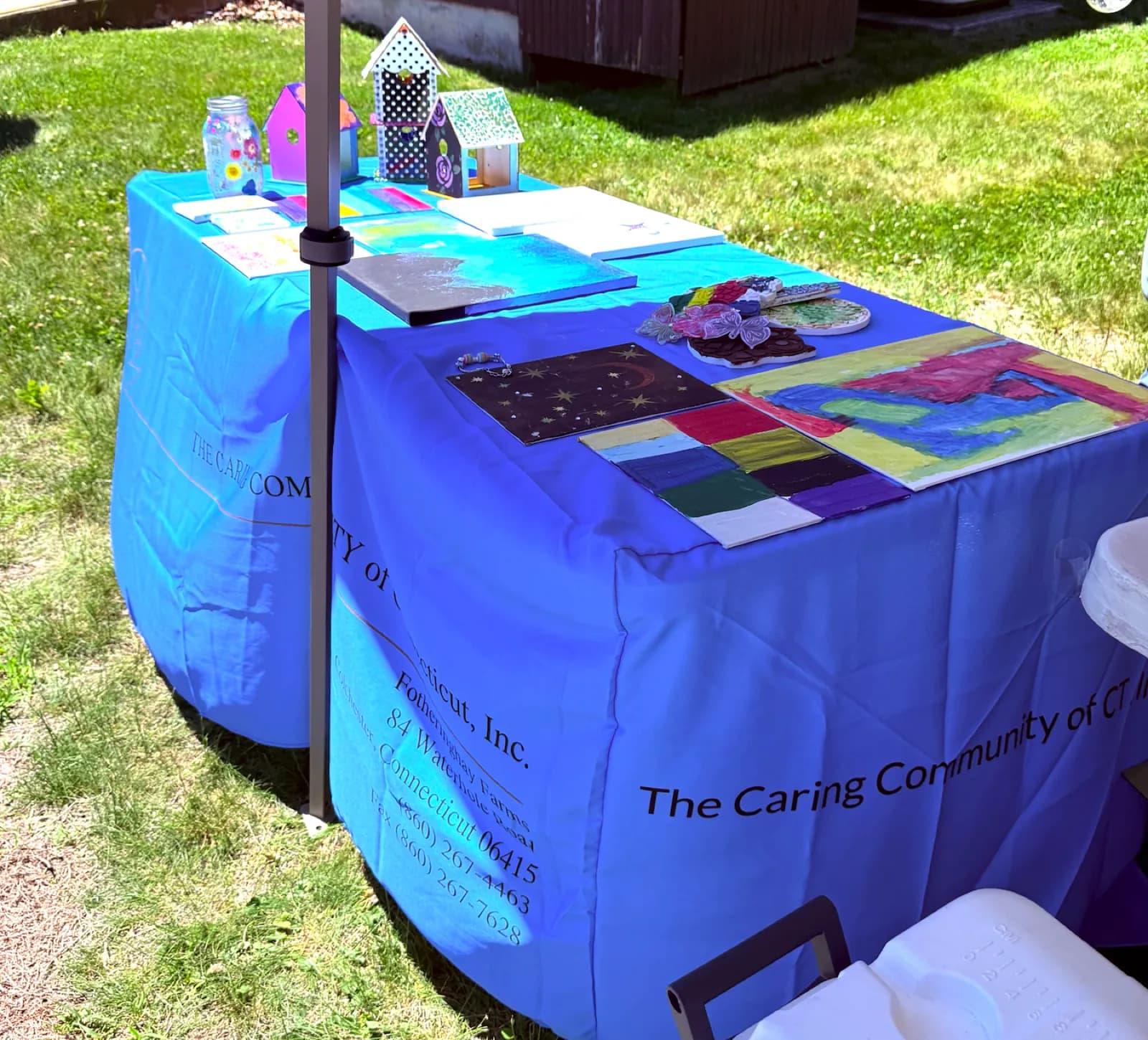 Handmade artwork and creative projects displayed on an outdoor community table