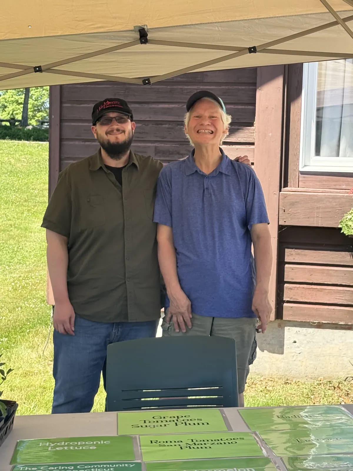 Two people smiling together at an outdoor community table